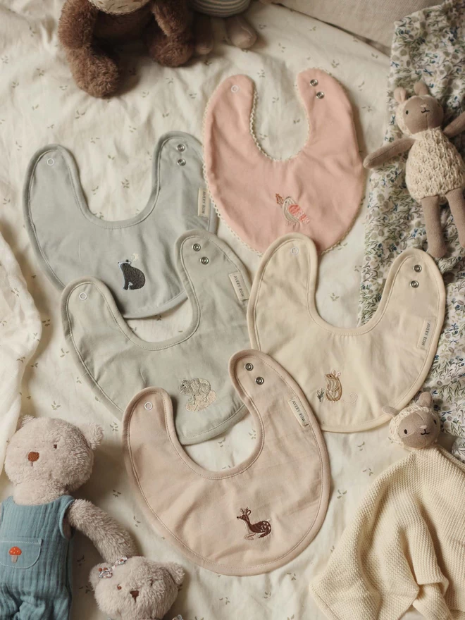 A collection of cotton bibs with different embroidery