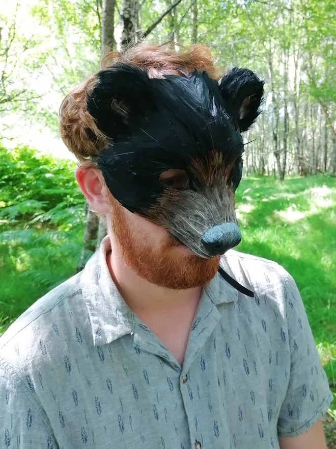 A man wearing a luxury black bear party mask down over his face