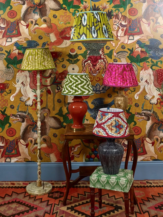 Collection of Five Colorful Ikat Lampshades in a Patterned Wallpapered Room