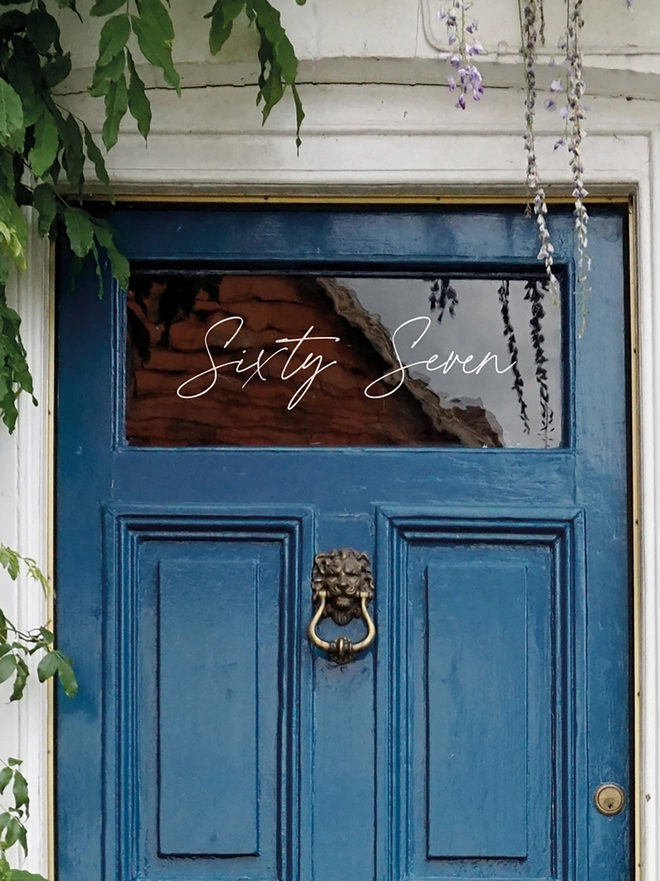 Close up of Handwritten Script, Front Door Number Sticker Decal on window above a blue front door