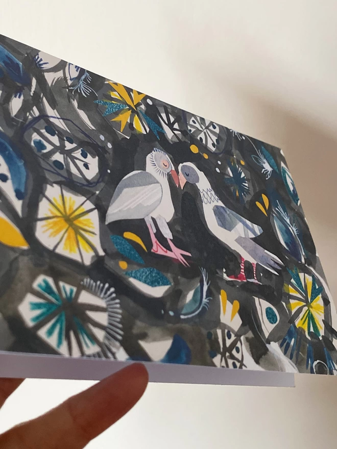 Black, grey, yellow and blie illustrated greetings card by Esther Kent shows two mouring doves surrounded by a pattern of stylised foliage.