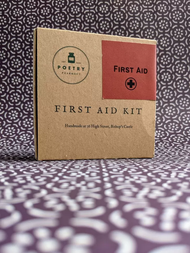 Cardboard poetry First Aid Kit displayed on patterned paper