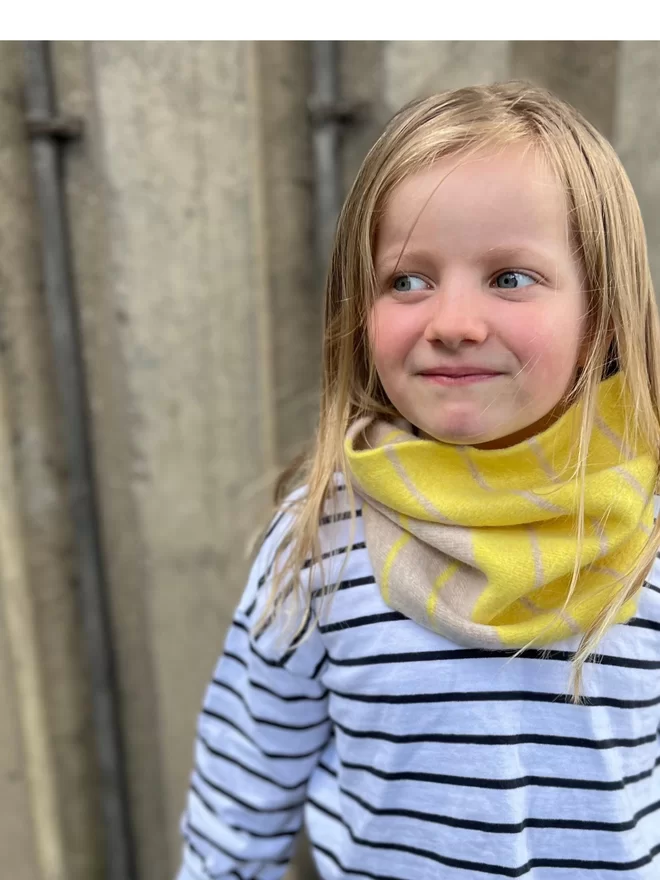Yellow oatmeal knitted snood being worn by a child