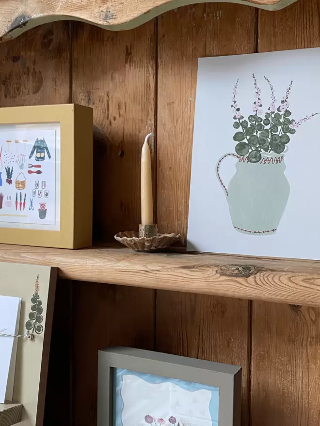 Hollyhocks floral a5 print on antiques wooden shelving. 