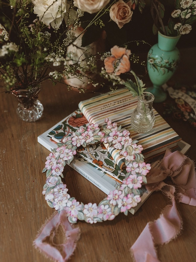 Wooden Blossom Garland, set amongst some books and fresh flowers