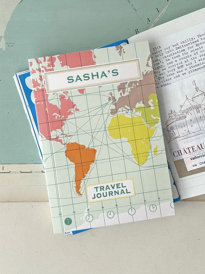 World map travel journal lifestyle shot on open book