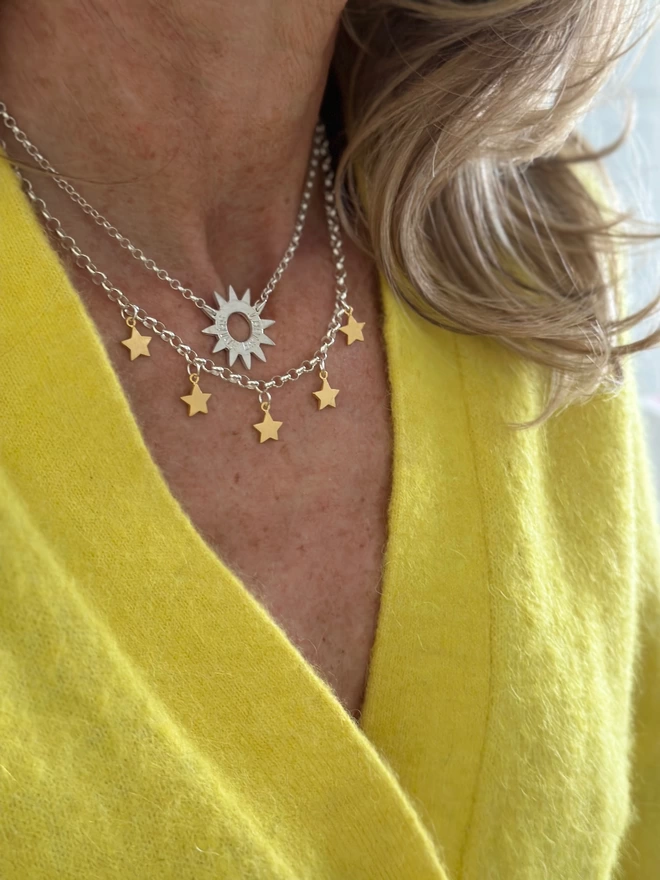 sterling silver sun charm on silver chain and a silver necklace with 5 gold mini stars