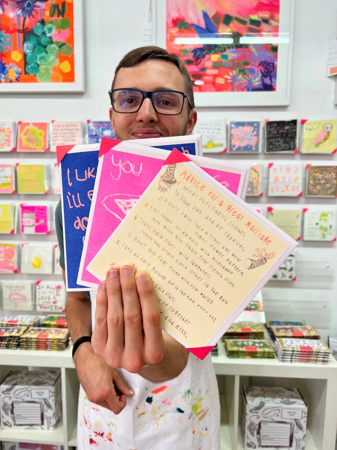 Artist holding a riso printed congratulations card featuring the words Advice for a Great Marriage 