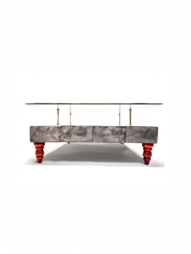 coffee table sat on red feet with glass top