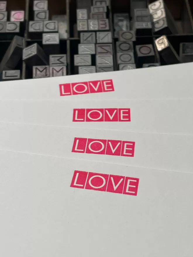 South London Letterpress Love Notecards in Neon Pink with the printing blocks seen behind.