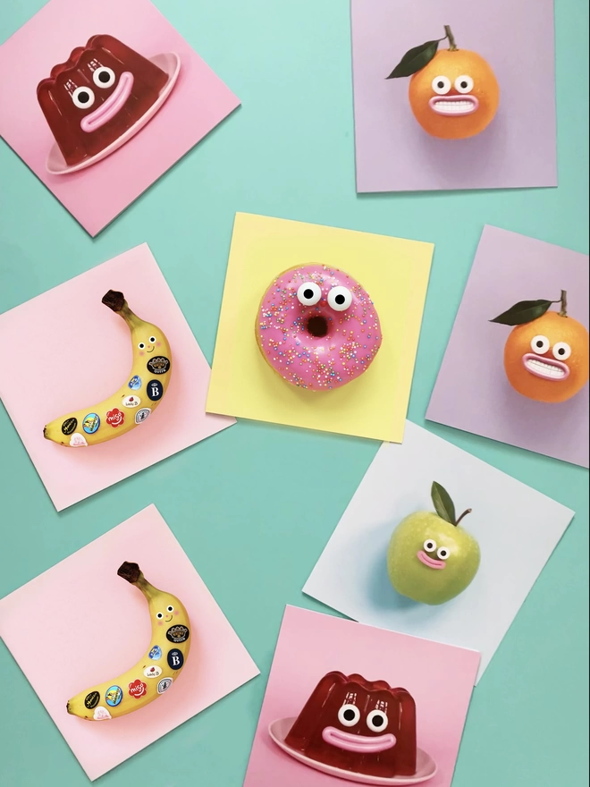 A collection of colourful cards. A jelly, banana, doughnut, apple and orange. 