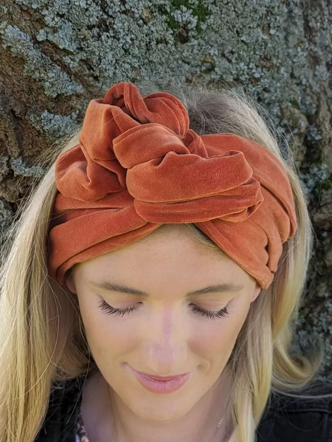 Orange velvet headband on blonde haired woman