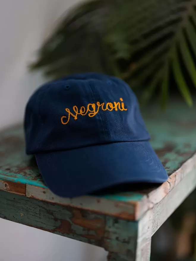 Navy Blue adults relaxed style cap with gold embroidery reading 'Negroni' in cursive lettering