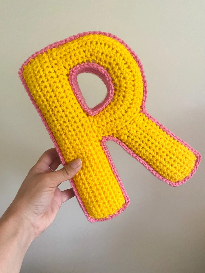 Cushion shaped like an R in Sunshine Yellow and Bubblegum Pink