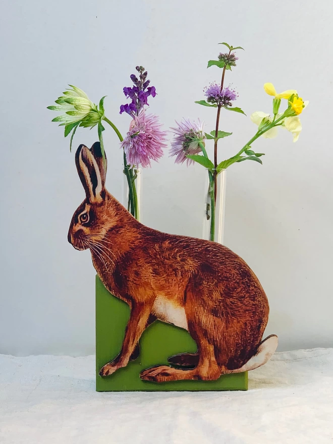 A test tube vase with cutout hare decoration.