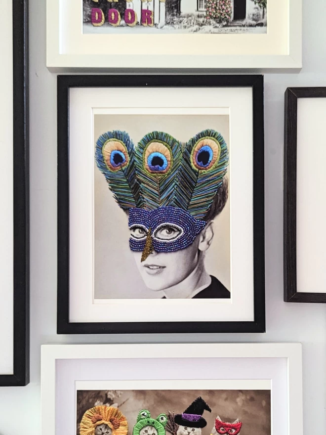 Print of woman wearing embroidered peacock mask hung on wall