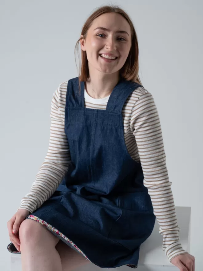 Trapeze line denim pinafore dress. Knee length with 2 large patch pockets.