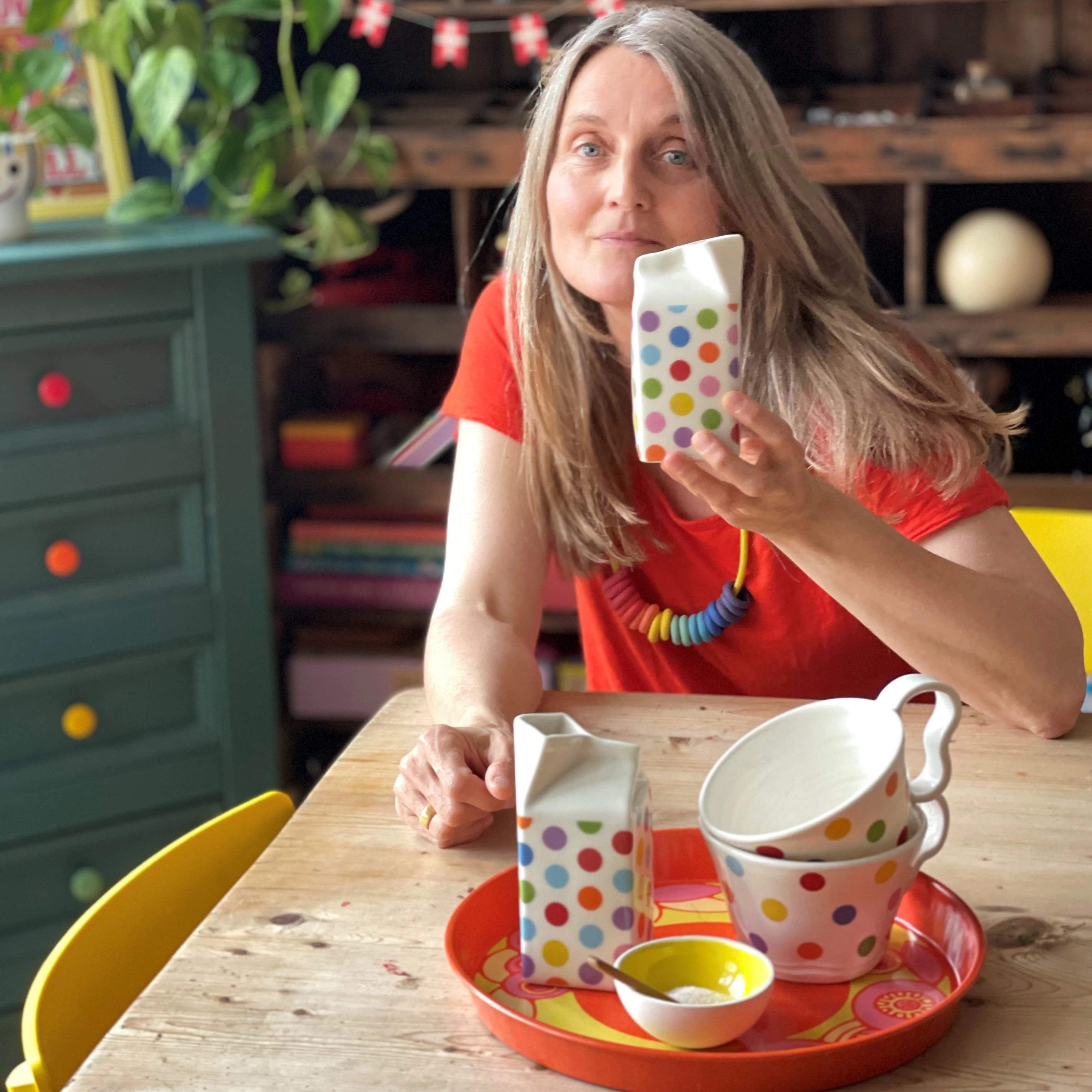 Hanne Rysgaard in her studio holding a polkadot milkcarton jug