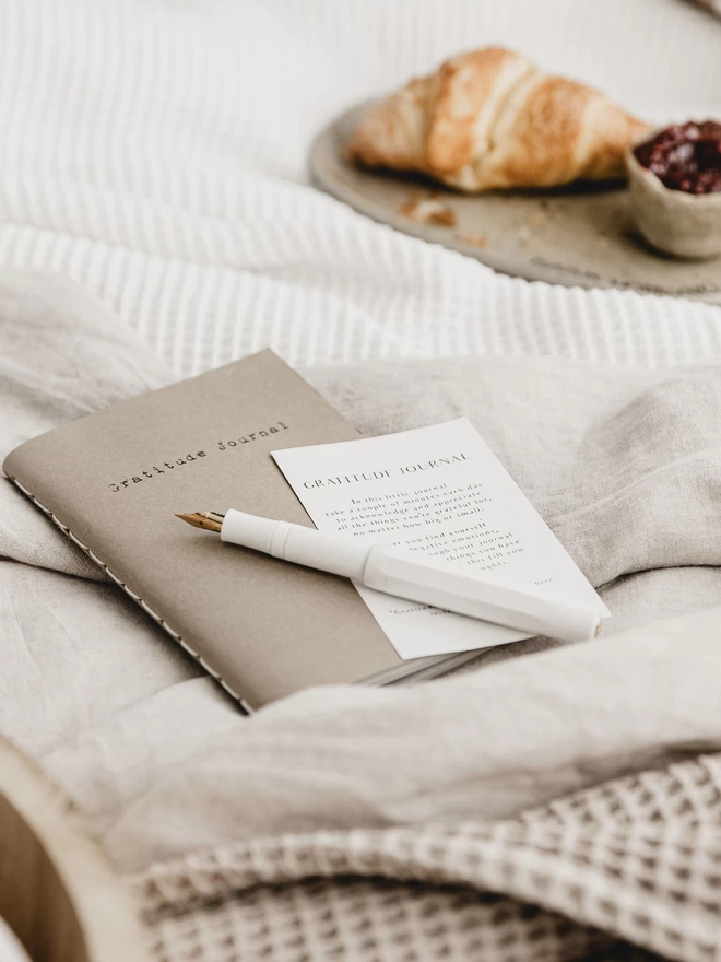 closed gratitude journal laid on a bed