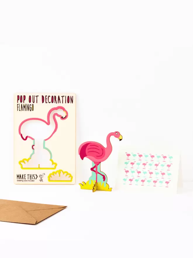 Pink flamingo decoration and flamingo pattern greeting card and brown kraft envelope on a white background
