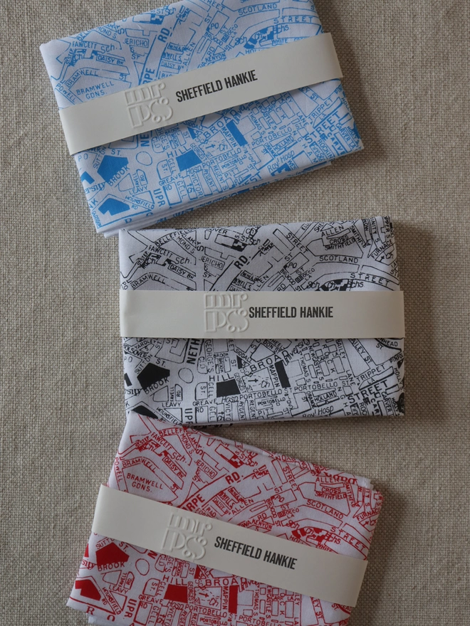 Three folded Mr.PS Sheffield map hankies to show the colour options available: sky blue, charcoal grey and red