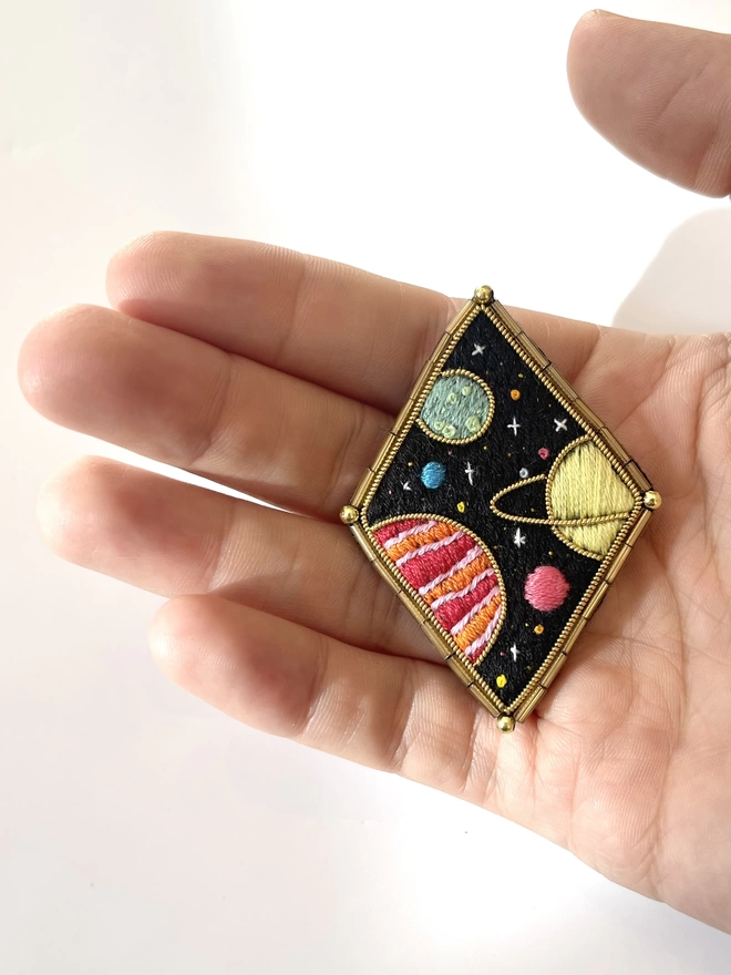 Planets brooch on hand