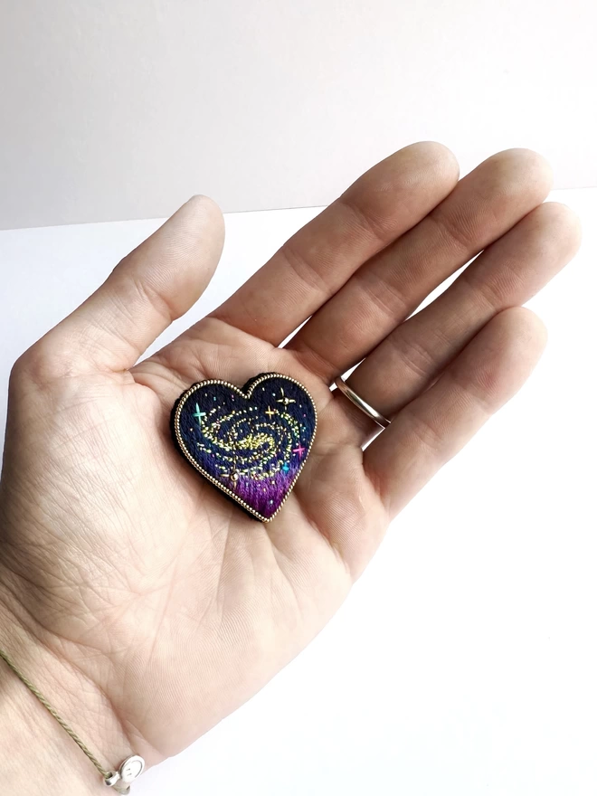 cosmic heart brooch in hand