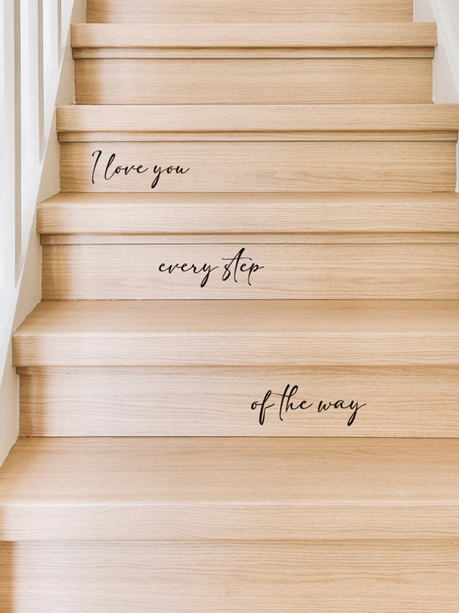 Close up of I Love You Every Step Of The Way Stair Sticker Decal on light wooden stairs