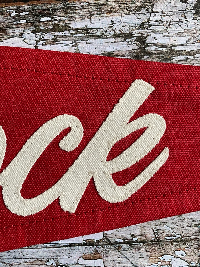 A close up section of a red Pimms O'clock pennant flag