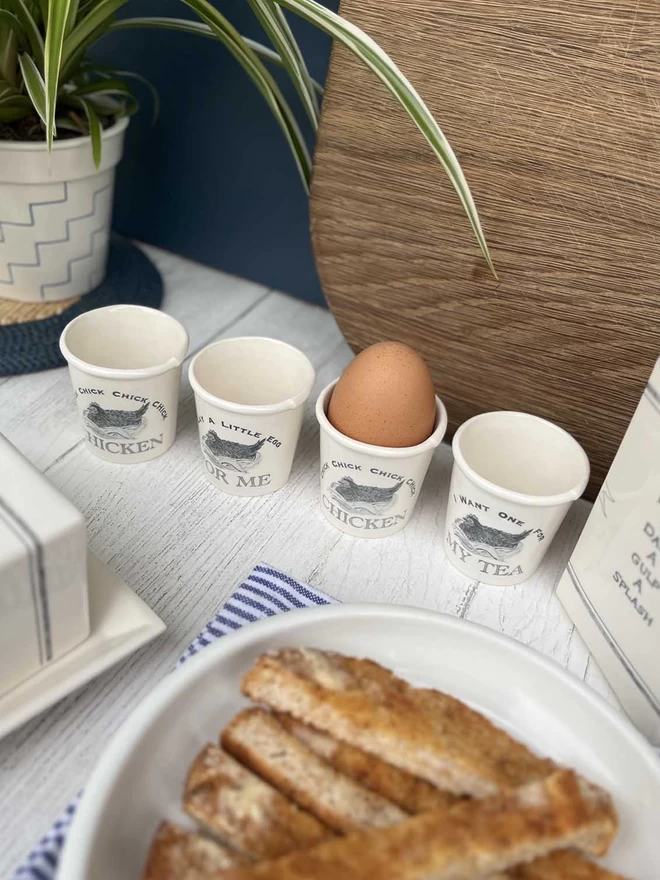 4 handmade egg cups, emulating a paper cup, featuring Beatrice von Preussen Illustrations of a Hen.