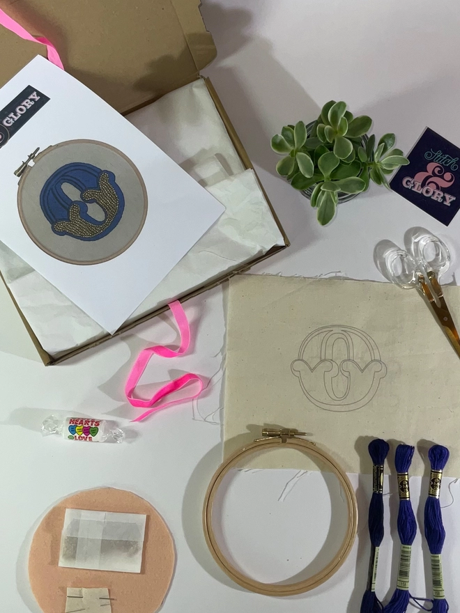 The contents of an embroidery kit laid out on a flat surface