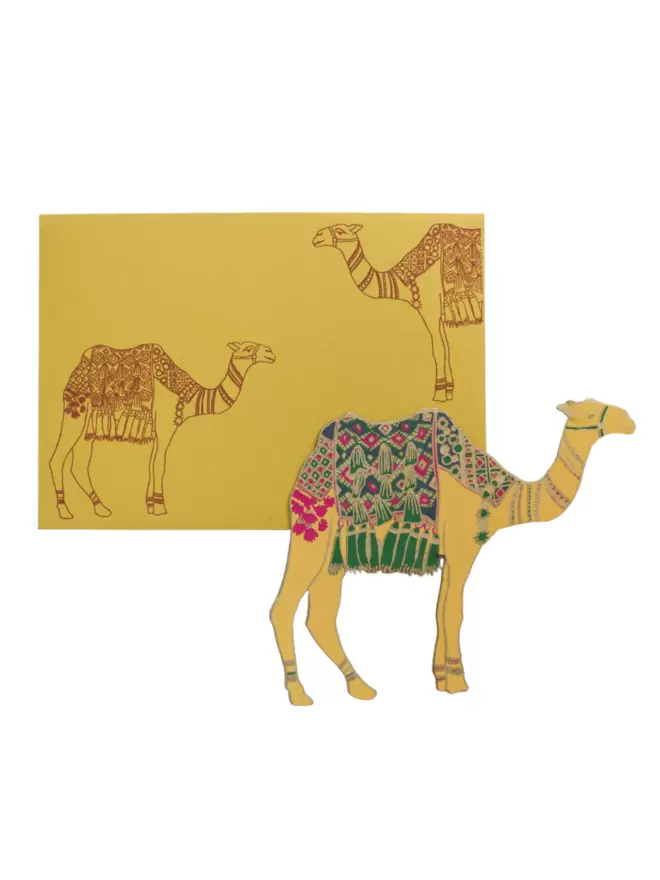 White cut-out shot: yellow camel with green blanket, matching yellow envelope with camel motif