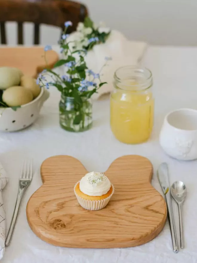 Wooden Bunny Serving Board with a cupcake in the centre of the board high angle