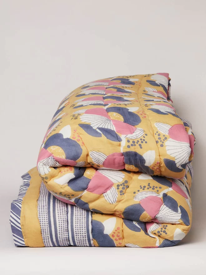 Folded yellow floral block printed quilt