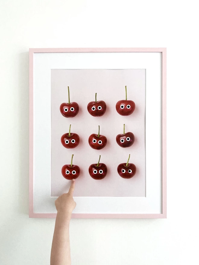 A3 print of 9 cheerful cherry's with a little girl pointing to the print 