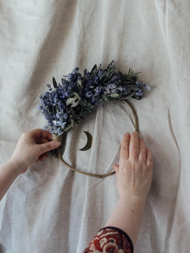 Dried Flower Wreath on a White Background with Hands Holding it up