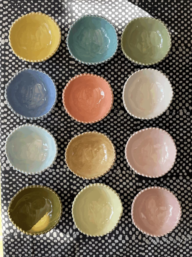 a top view looking into pinch pots in a variety of colours, colour chart