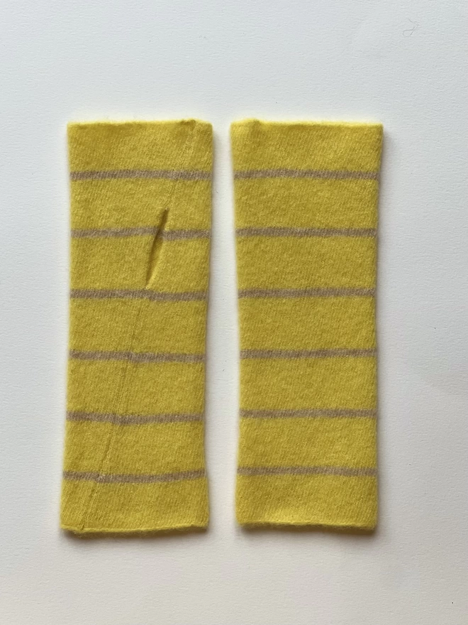 Yellow knitted wristwarmers laid flat next teach other