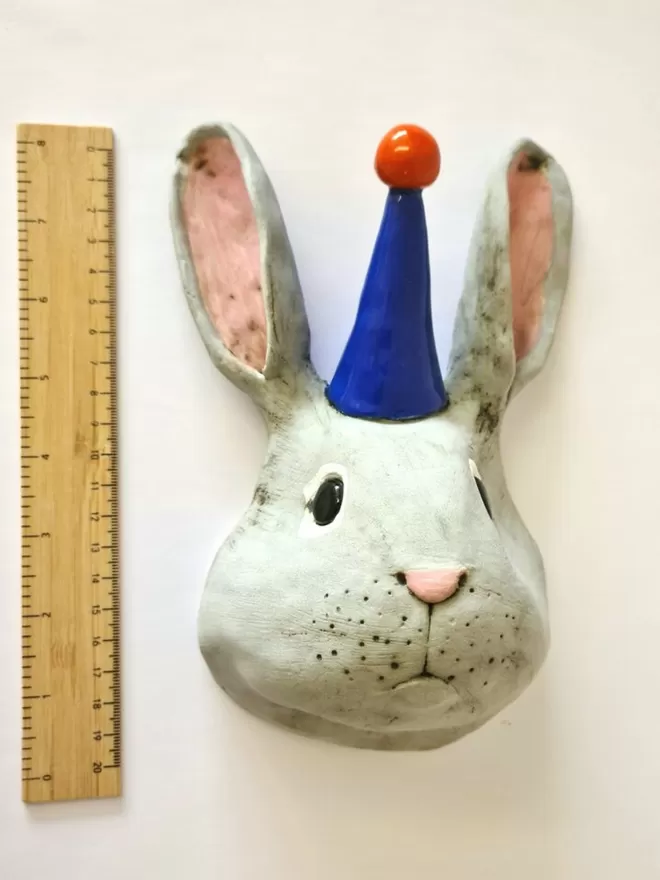 Bobby the rabbit trophy style head seen next to a ruler for scale.