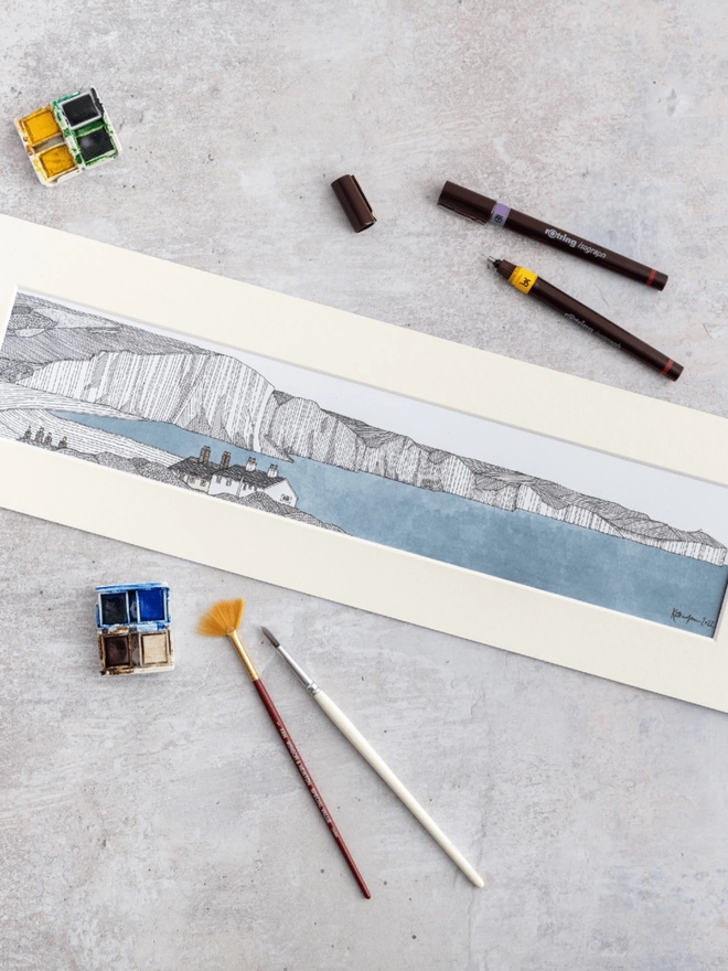 Print of a detailed pen and watercolour drawing of Seven Sisters cliffs, with cottage, in a soft white mount