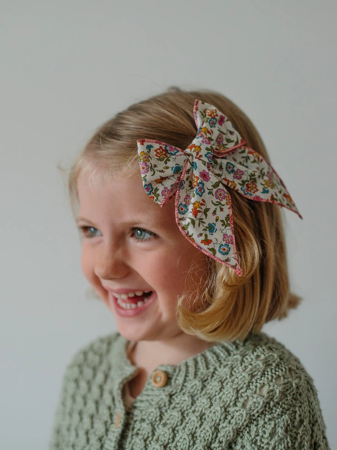 Little girl wearing a Liberty bow in the side of her hair
