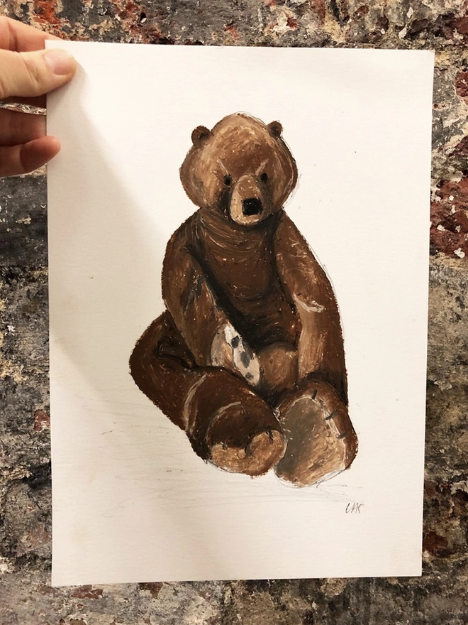 drawing of large brown bear toy against old brick wall