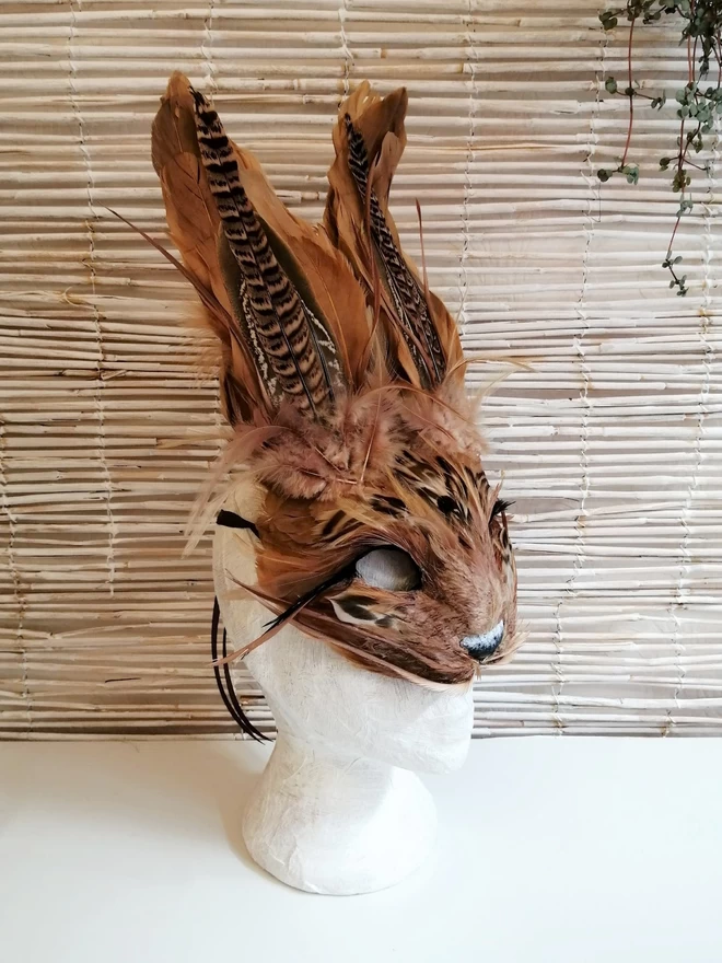 A luxury brown hare masquerade mask on a display mannequin head