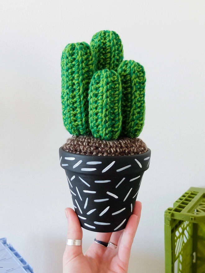 Green crocheted cactus in white and black hand-painted pot