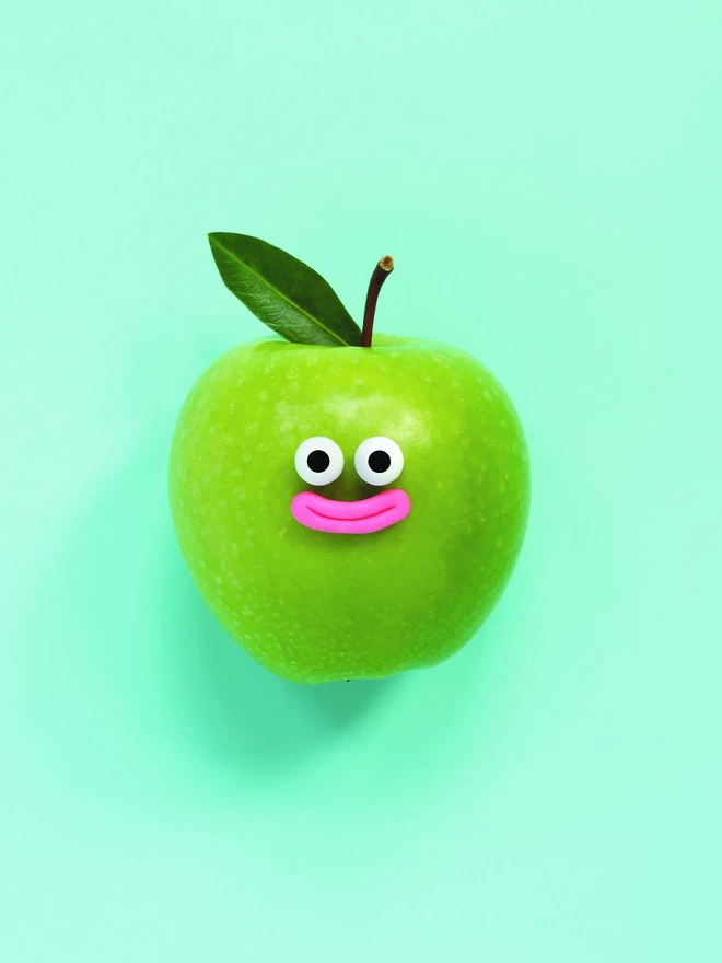 A happy green apple with a leaf on a blue background 