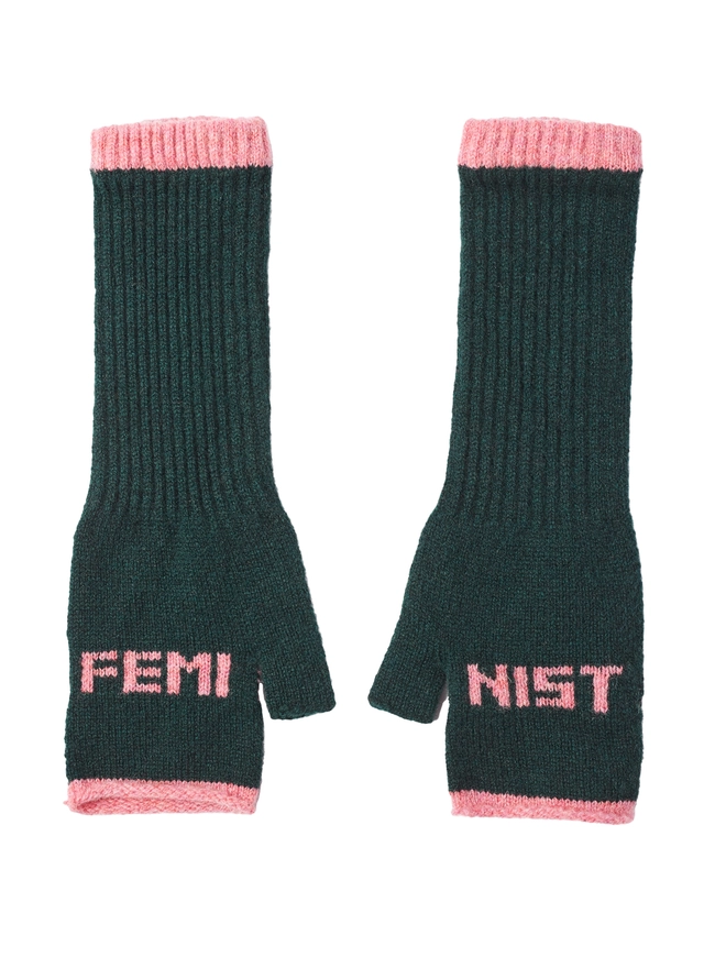 Wool fingerless mittens in forest green with pink lettering spelling Feminist