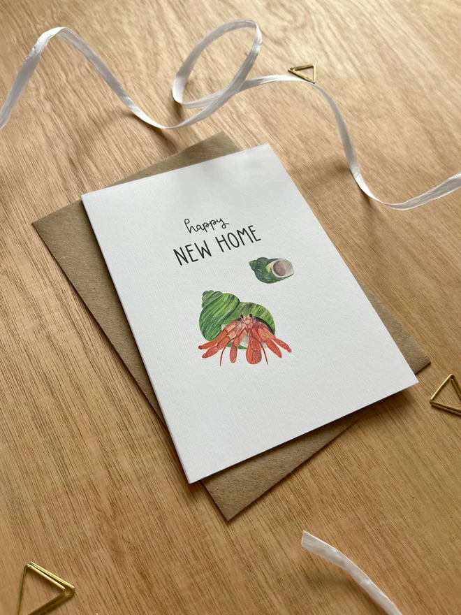 a greetings card featuring a hermit crab with the phrase “happy new home”