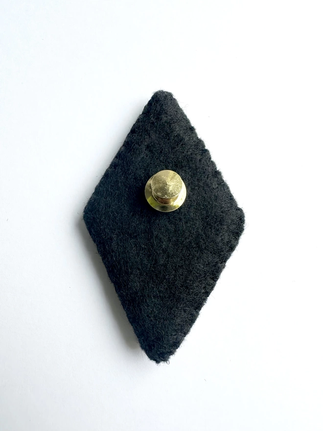 Black felt back of diamond shaped brooch with gold pin back 