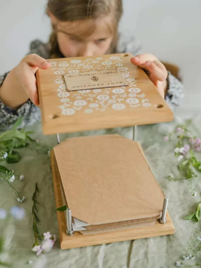 Wooden Flower Press - Delicate Daisy child using and assembling the flower press to press flowers