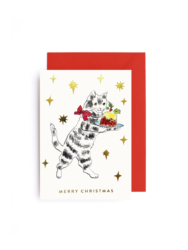 Greeting card that shows an image of a cat holding a christmas pudding, with gold star all around. It says Merry Christmas on the card